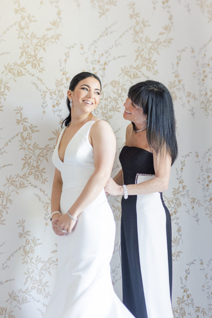 Bride and mom getting dressed in bridal suite