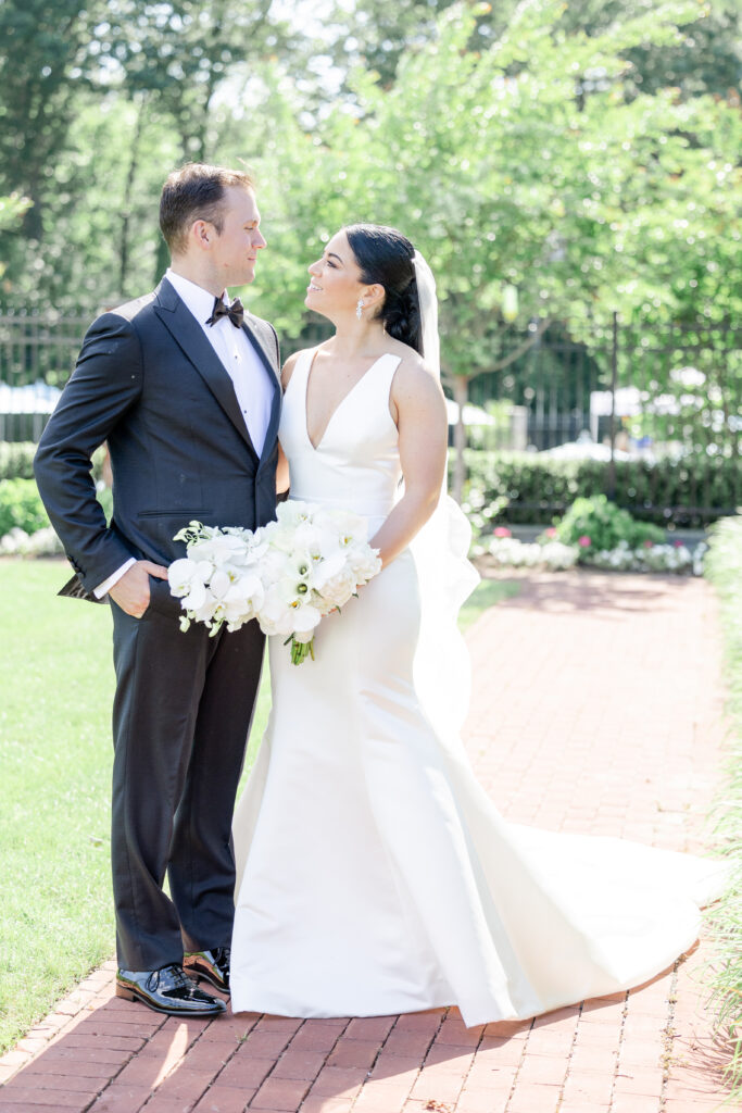 Bride and groom looking at each other outside golf club