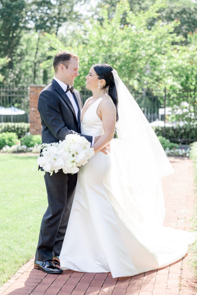 Bride and groom looking at each other outside golf club