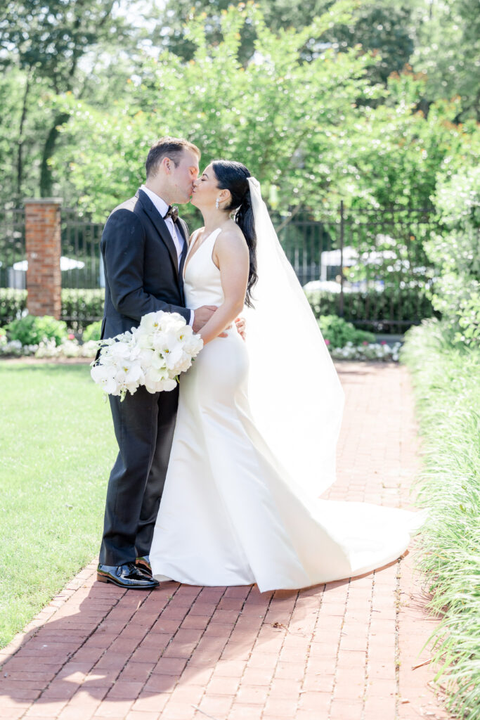 Bride and groom kissing outside golf club