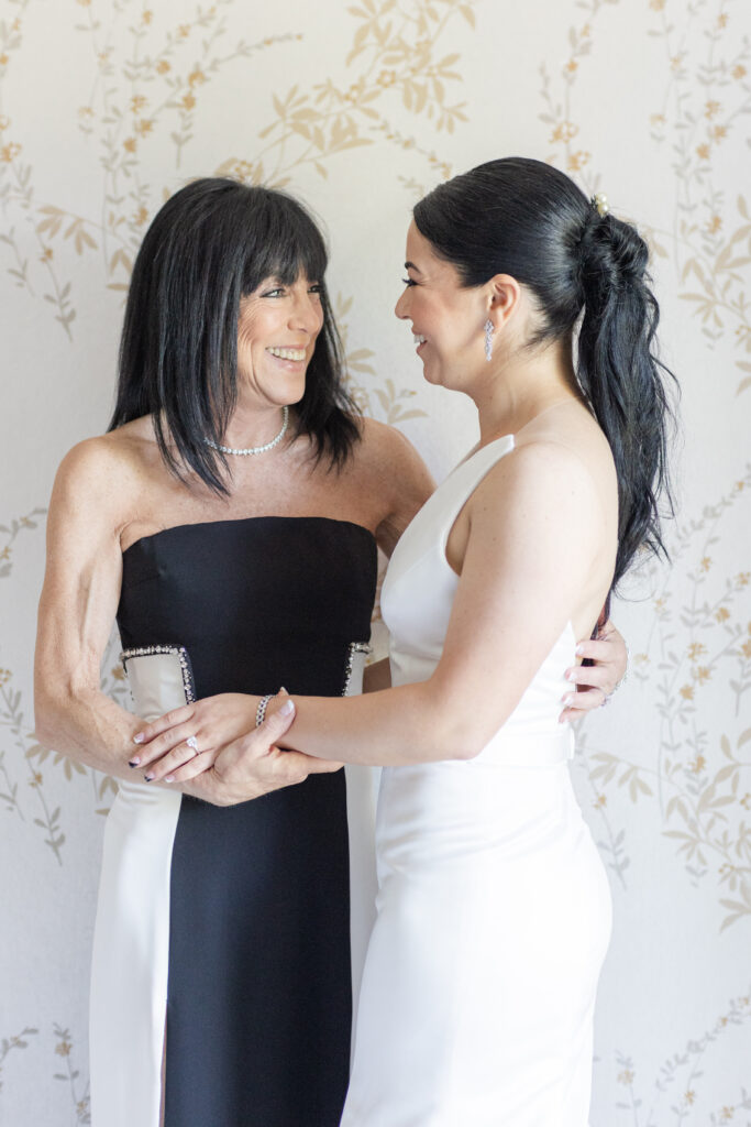 Bride and mom getting dressed in bridal suite