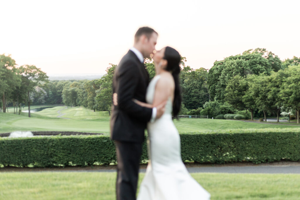 Bride and groom outdoor sunset portraits kissing