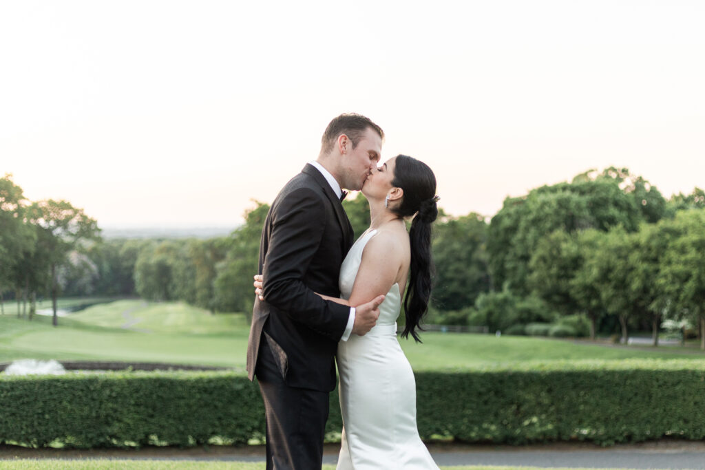 Bride and groom outdoor sunset portraits kissing