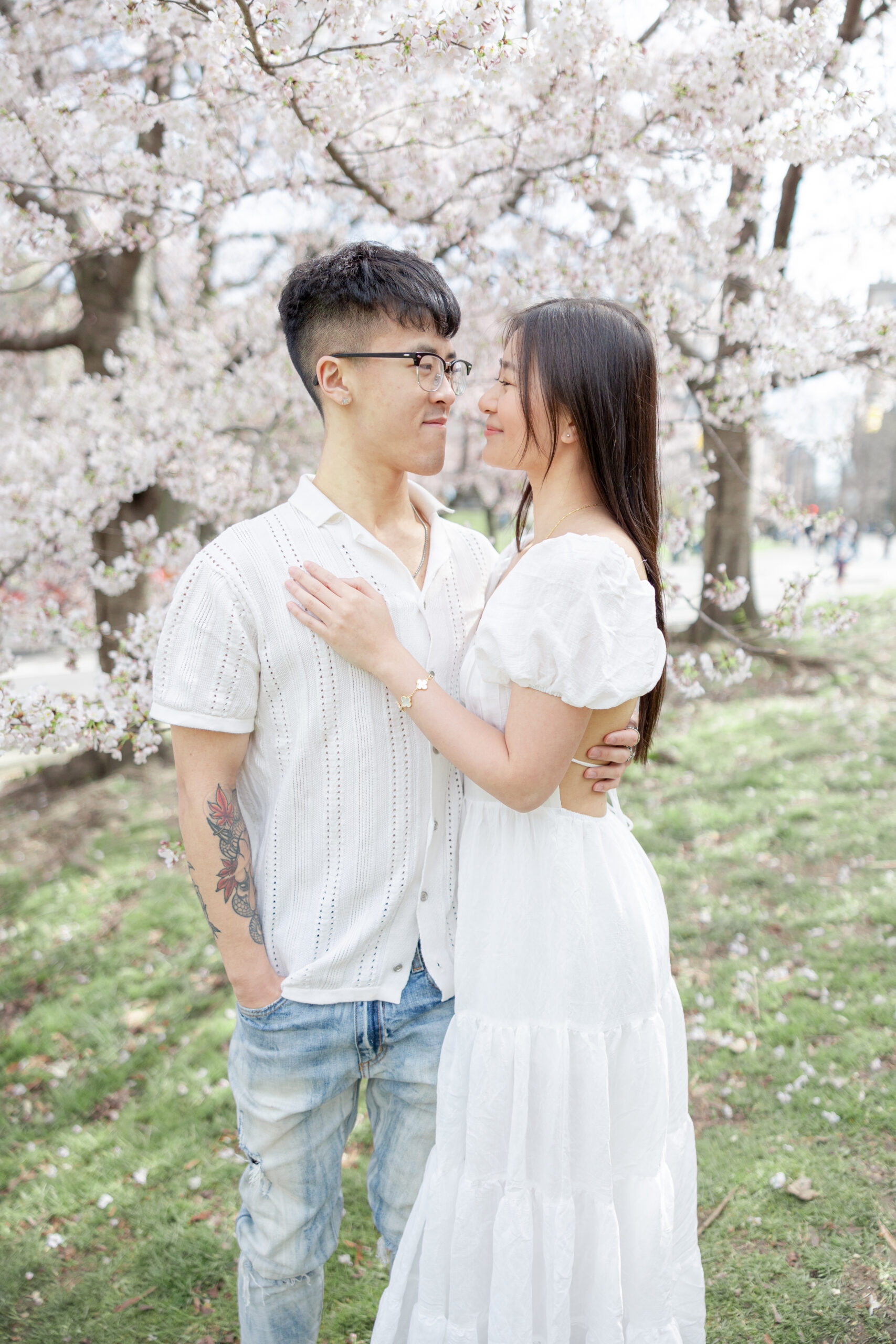 Intimate engagement in NYC with soft pink blossoms