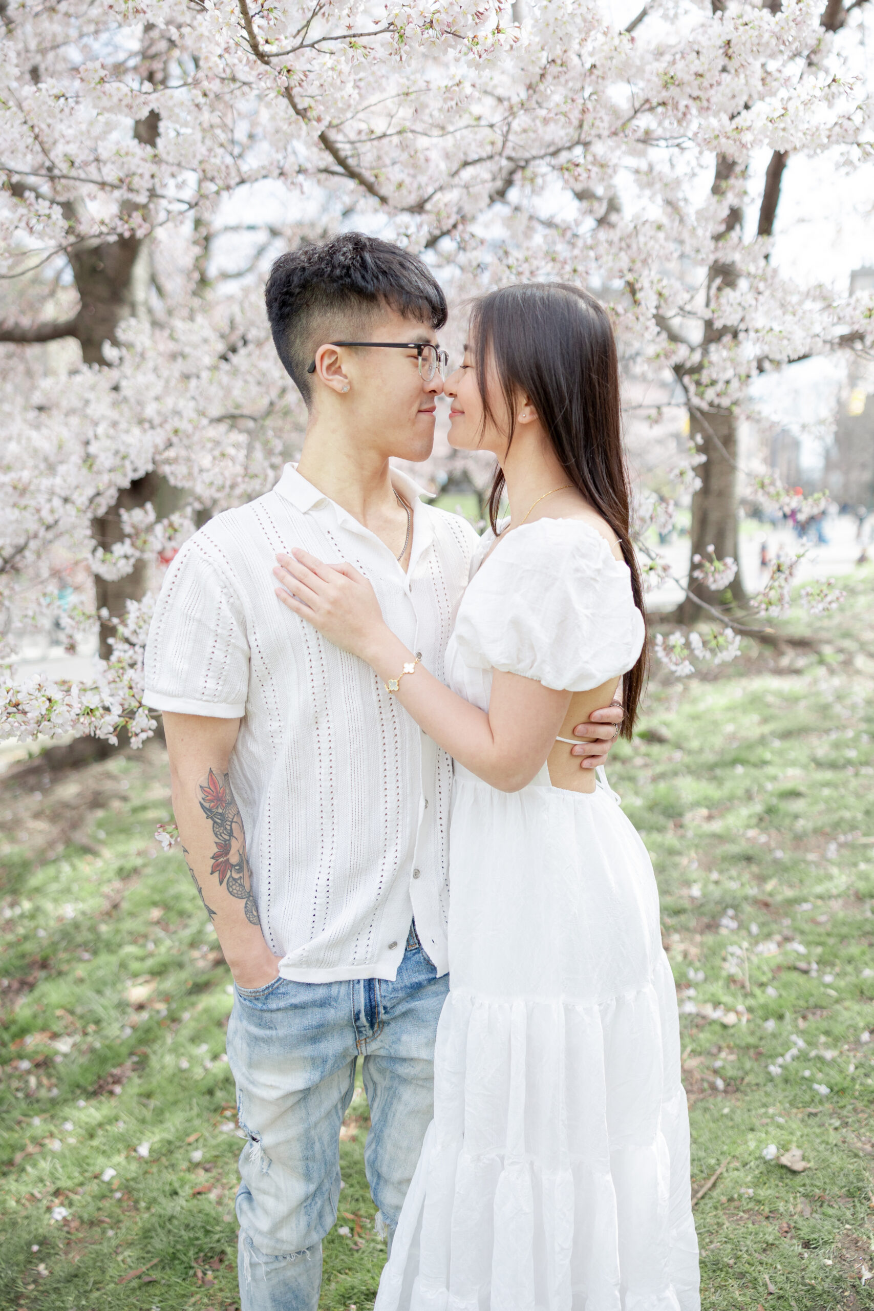 Intimate engagement in NYC with soft pink blossoms