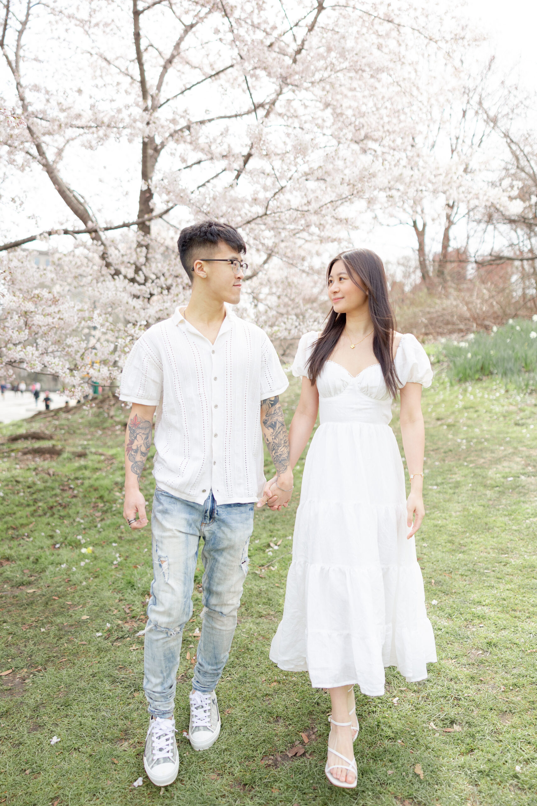 Editorial style NYC engagement photos with cherry blossom backdrop