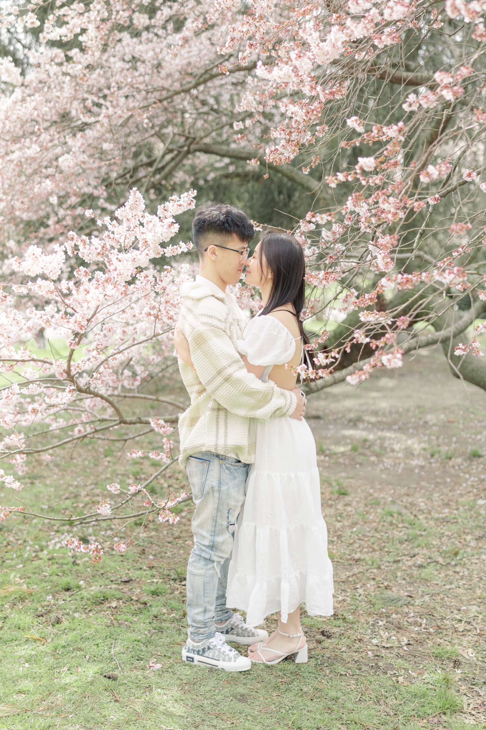 Editorial style NYC engagement photos with cherry blossom backdrop
