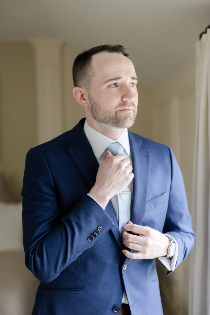 Groom fixing tie at Basking Ridge Hotel's suite