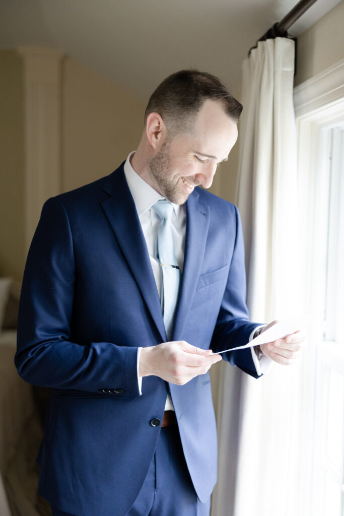 Groom reading bride's letter at groom's suite