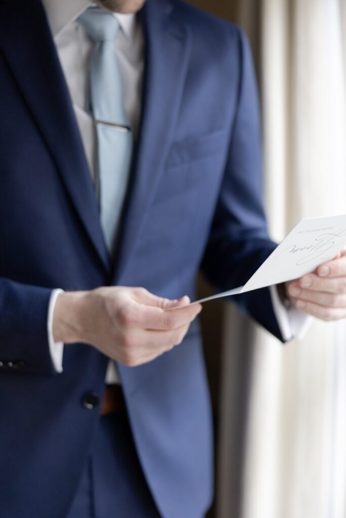 Groom reading bride's letter at groom's suite