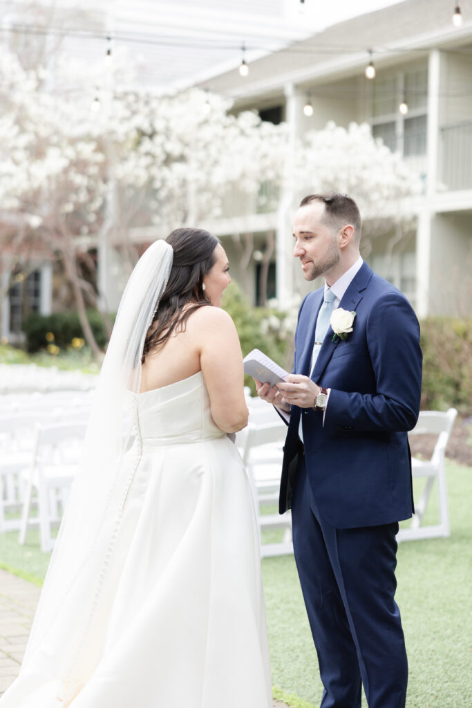 Groom reading private vows to bride outside luxury hotel wedding venue