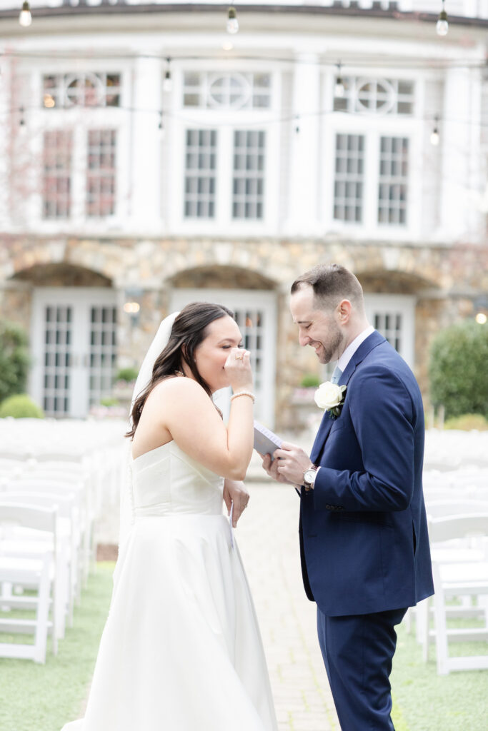 Groom reading private vows to bride outside luxury hotel wedding venue