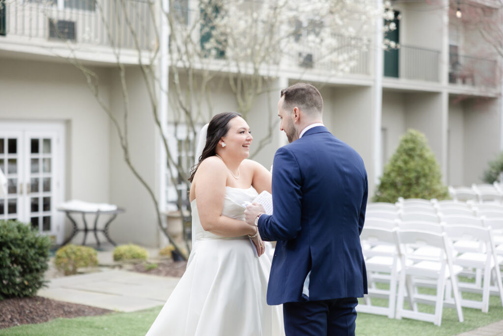 Groom reading private vows to bride outside luxury hotel wedding venue