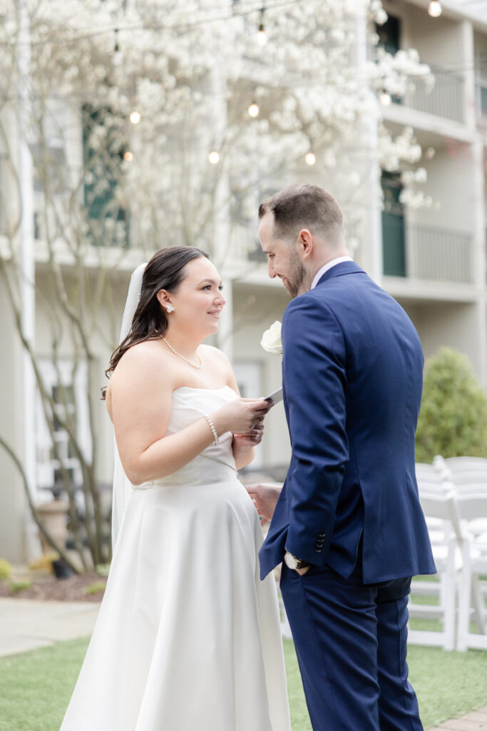 Bride reading private vows to groom outside luxury hotel wedding venue