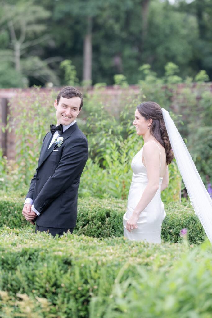 Outdoor first look at garden wedding venue between bride and groom