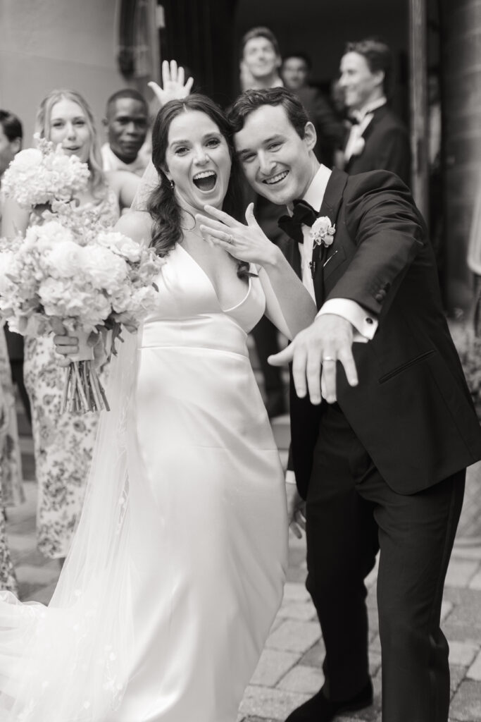 Black and white photo of just married moment of bride and groom outside of church