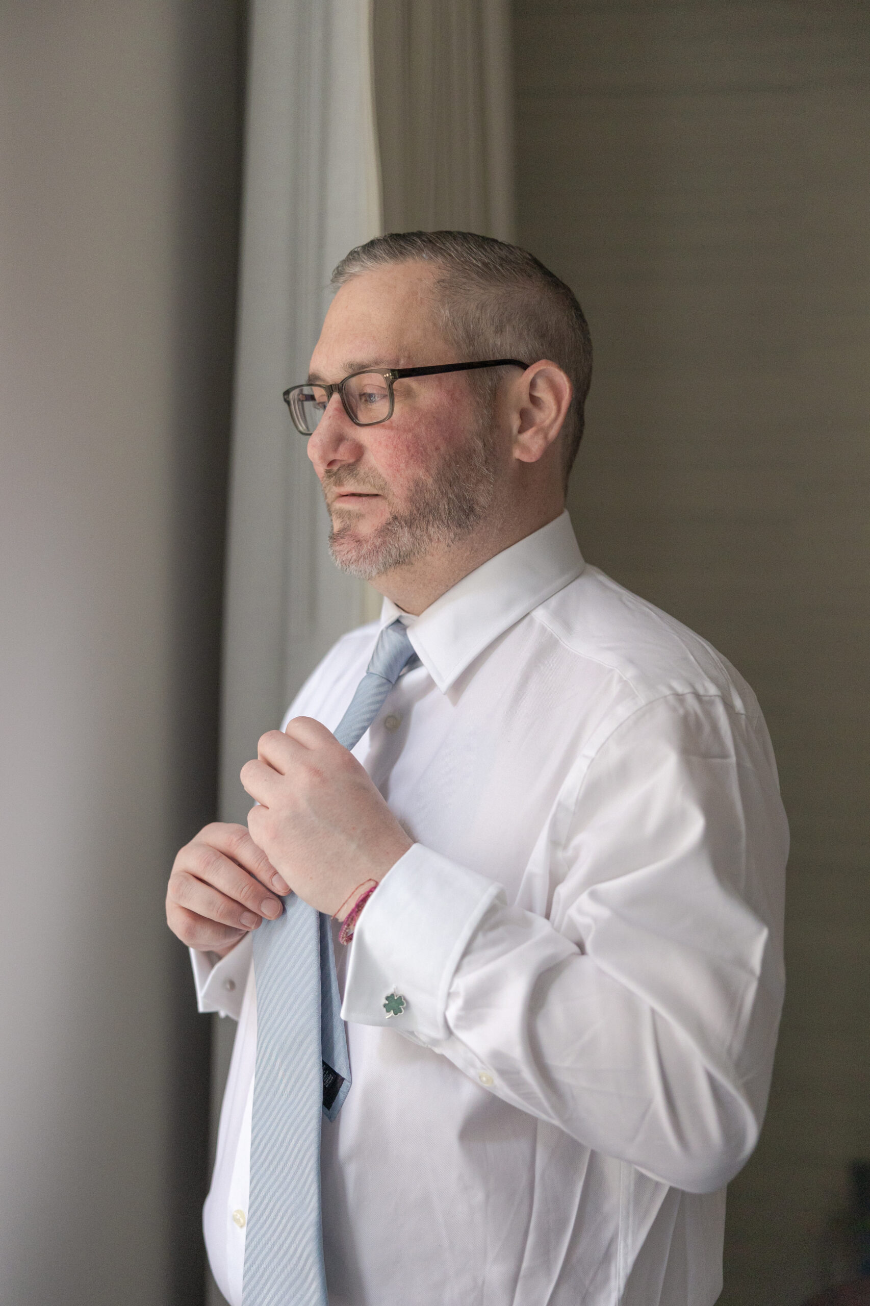 Groom in groomsmen suite fixing tie