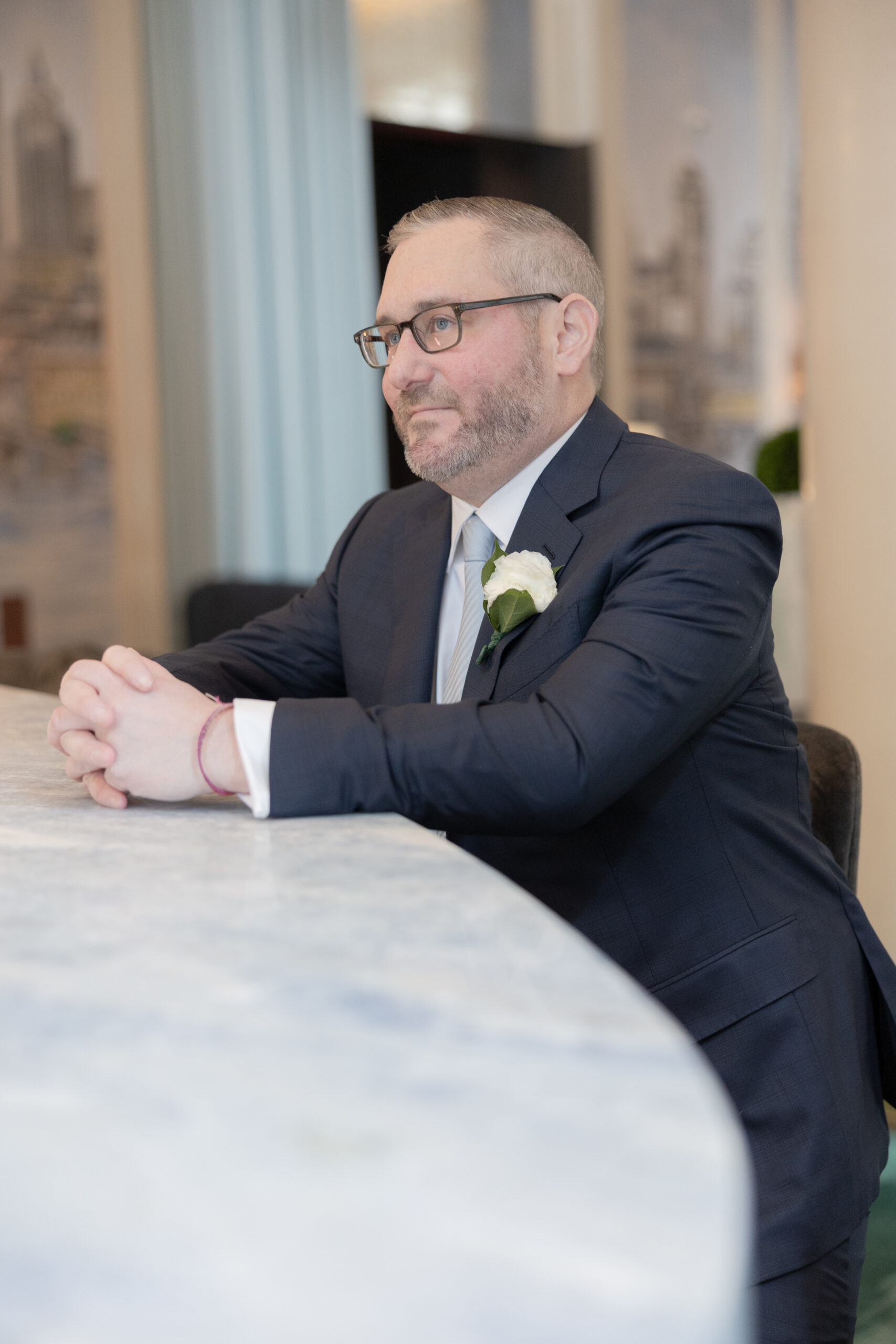 Groom sitting at Wall Street Hotel indoor bar