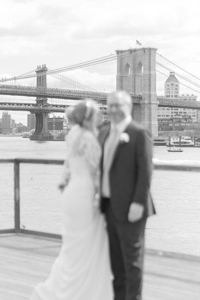 Black and white wedding portrait in front of Brooklyn Bridge