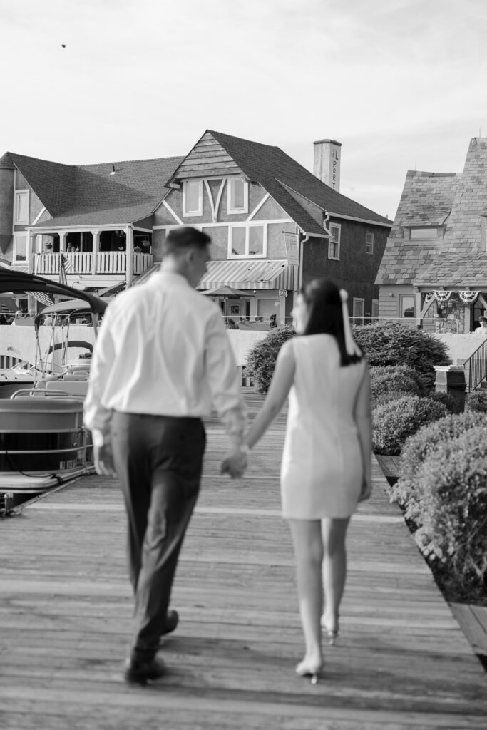 Black and white photo of couple walking through dock