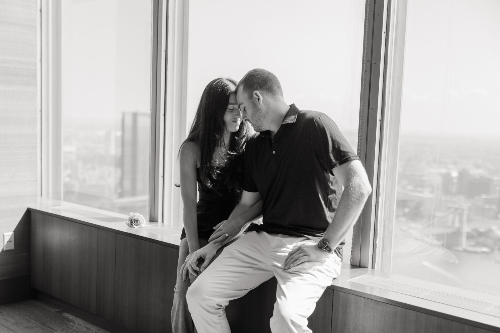 Black and white engagement photos in front of NYC skyline