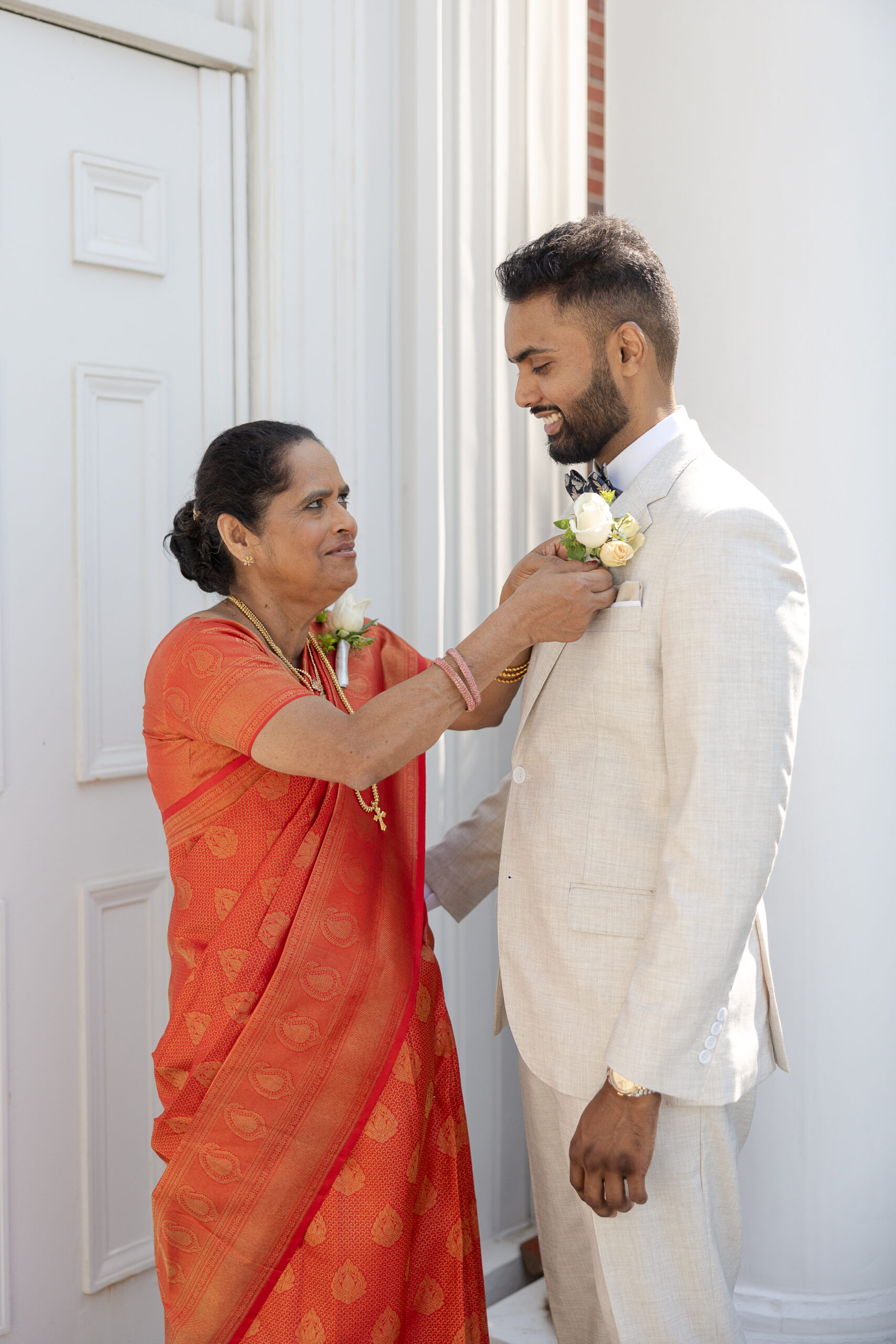 Groom getting dressed with mom for New York Catholic Indian Wedding