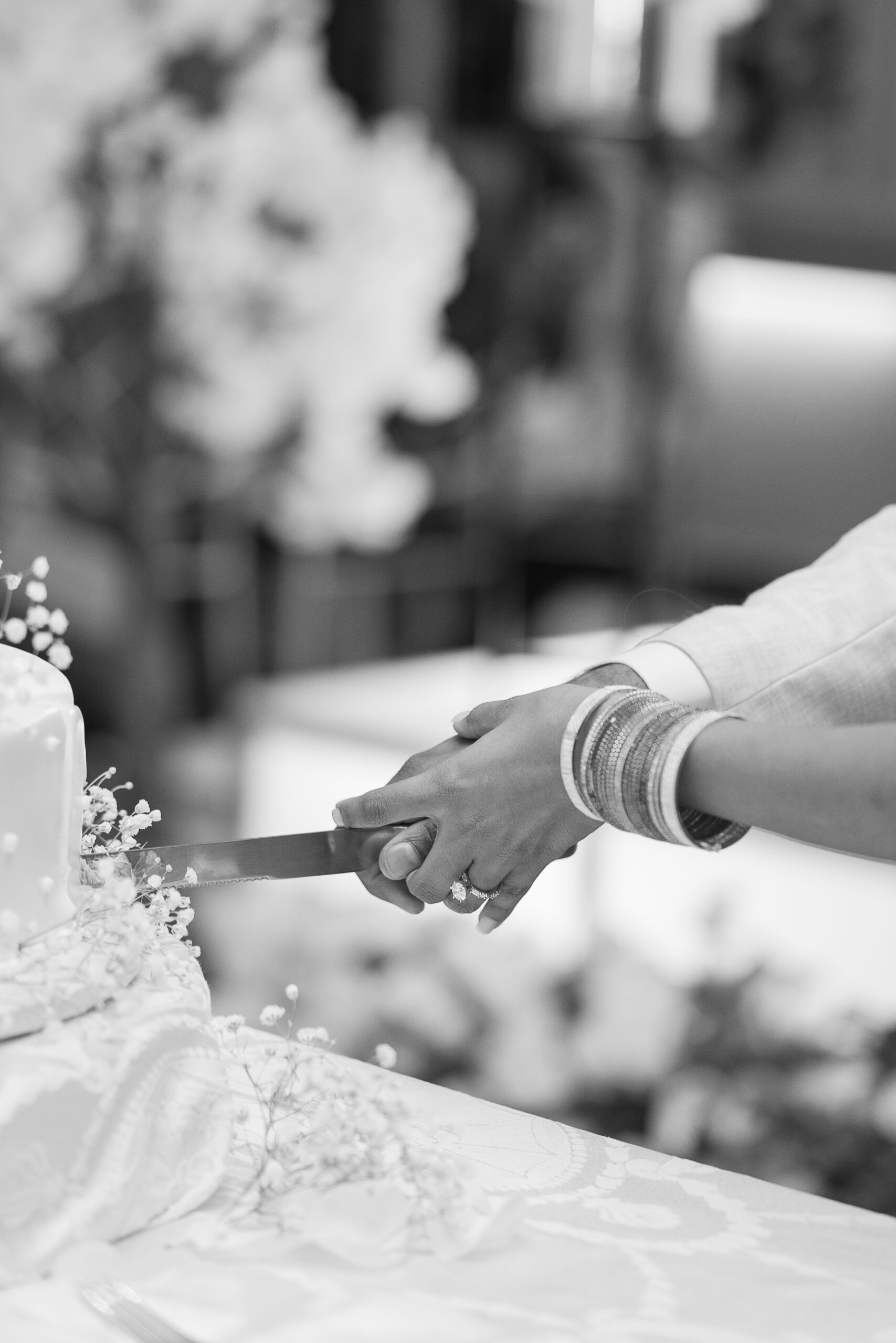 Black and white photo of bride and groom cutting cake