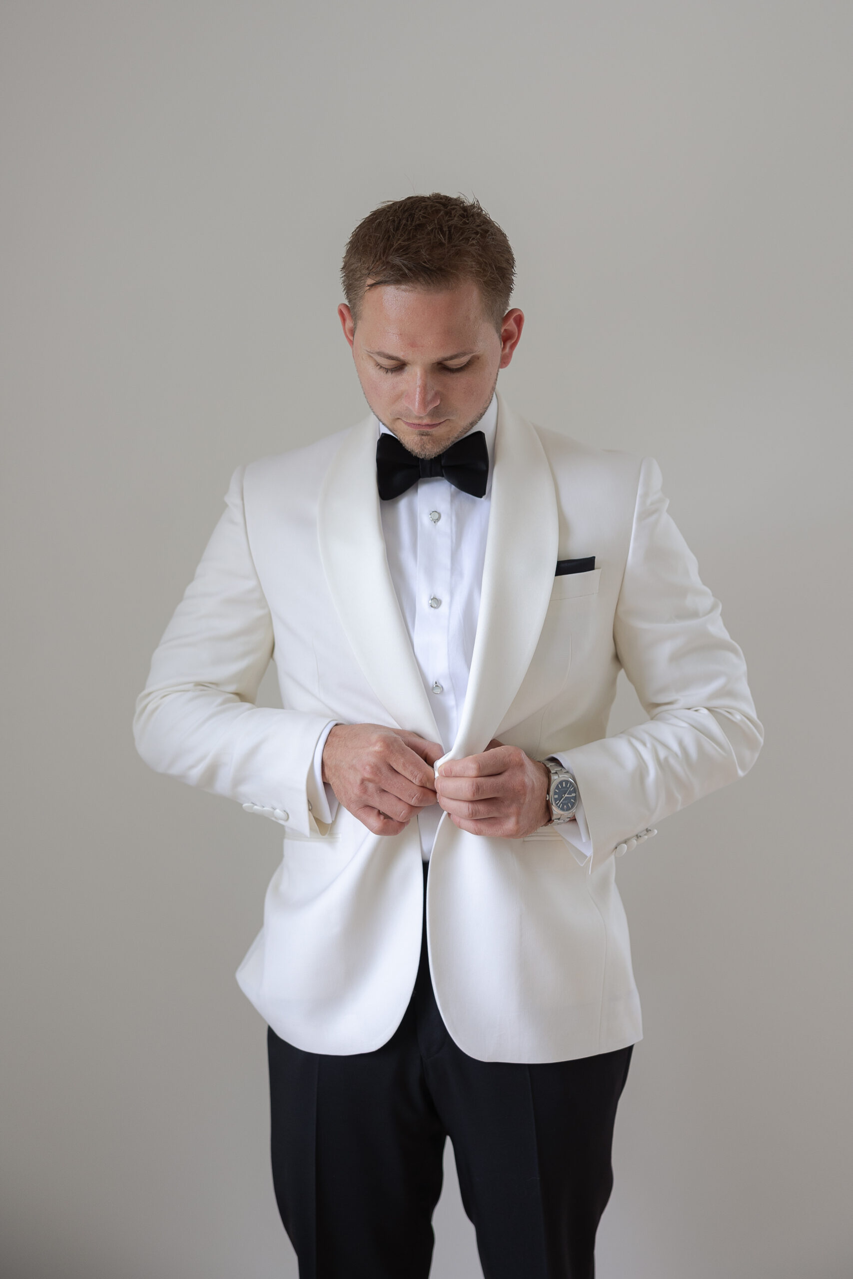 Groom getting dressed with white suit for New York Wedding day