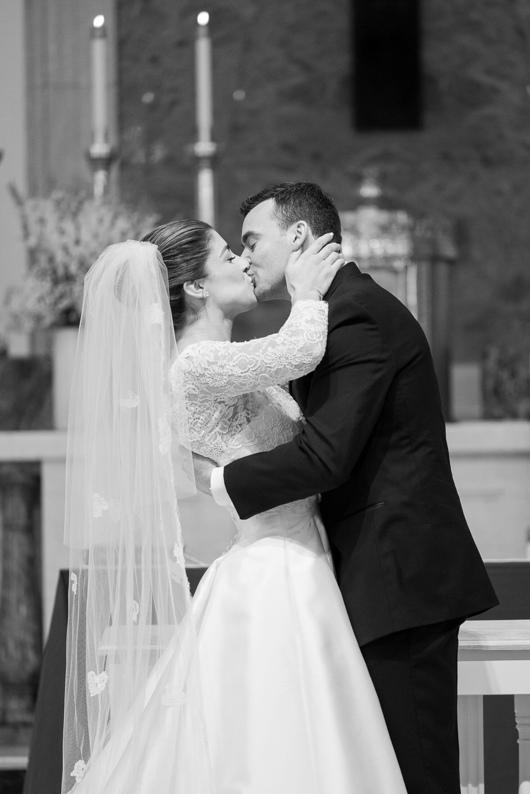 Black and white photo of bride and groom kiss