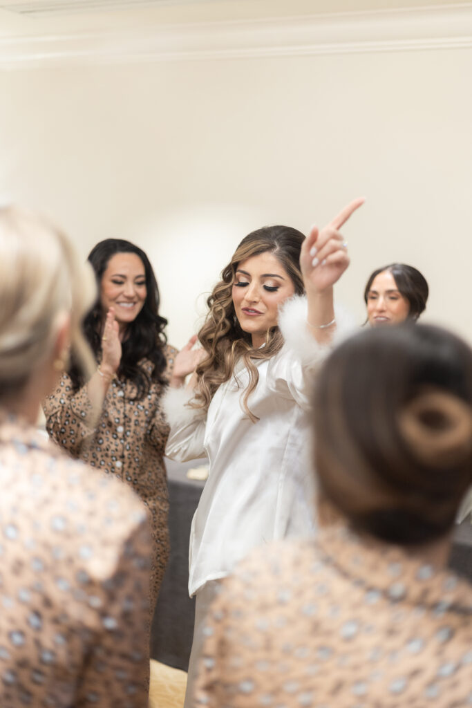 Bride and bridesmaid dancing at getting ready