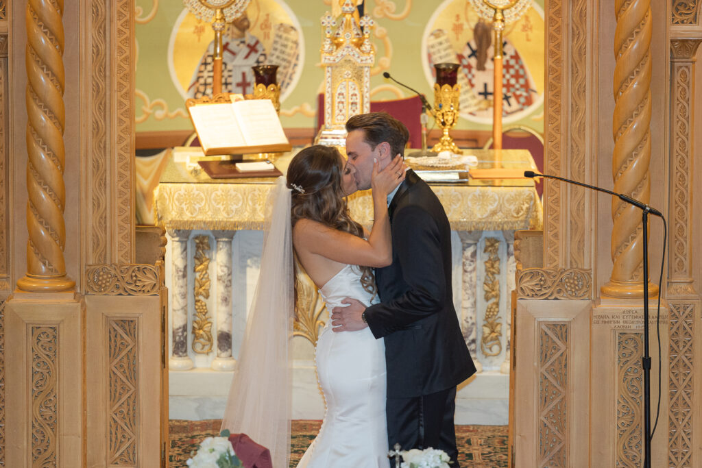 Greek bride and groom at first kiss