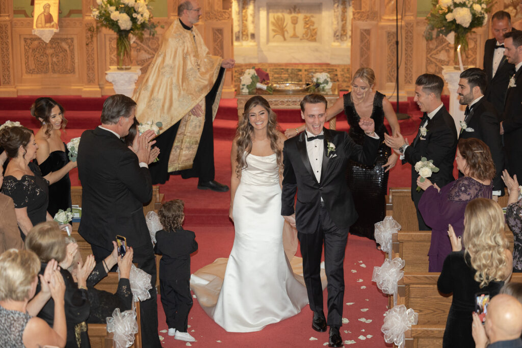 Greek bride and groom at walking down aisle