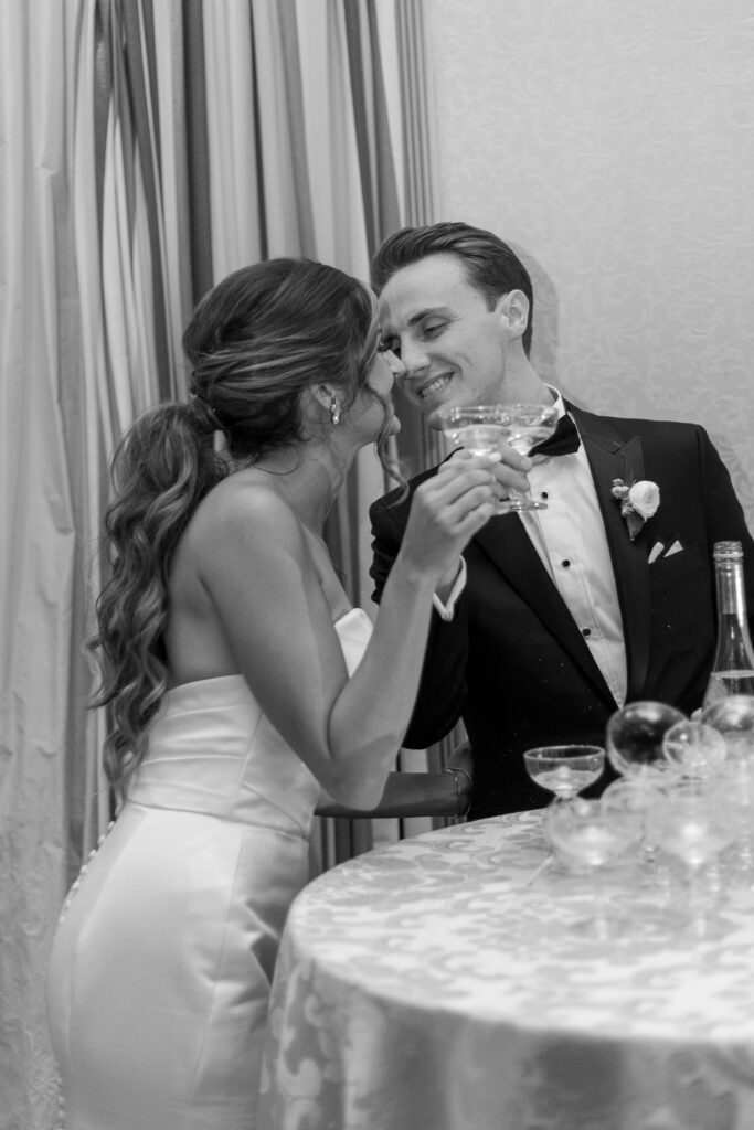 Bride and groom pouring on stacked glasses