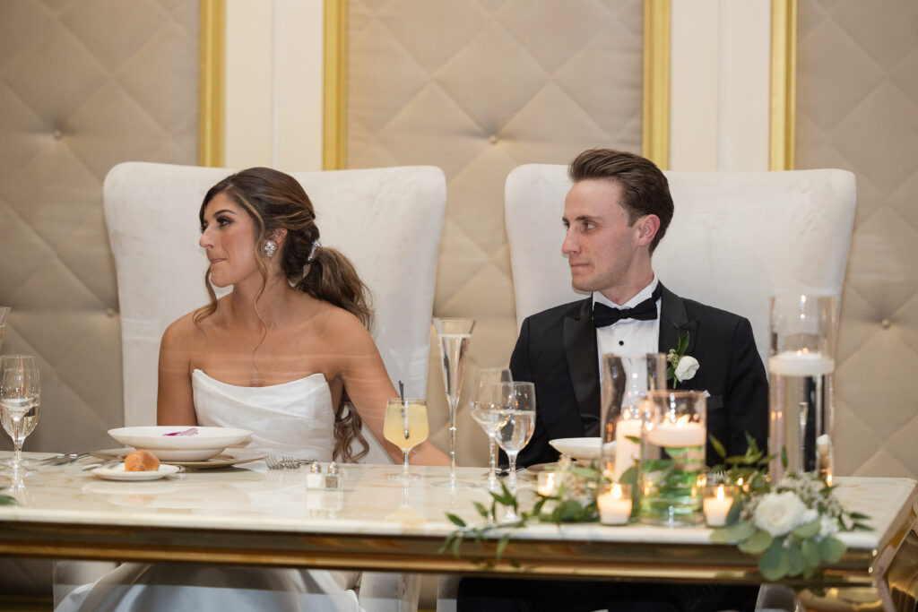 Bride and groom listening to speeches during reception
