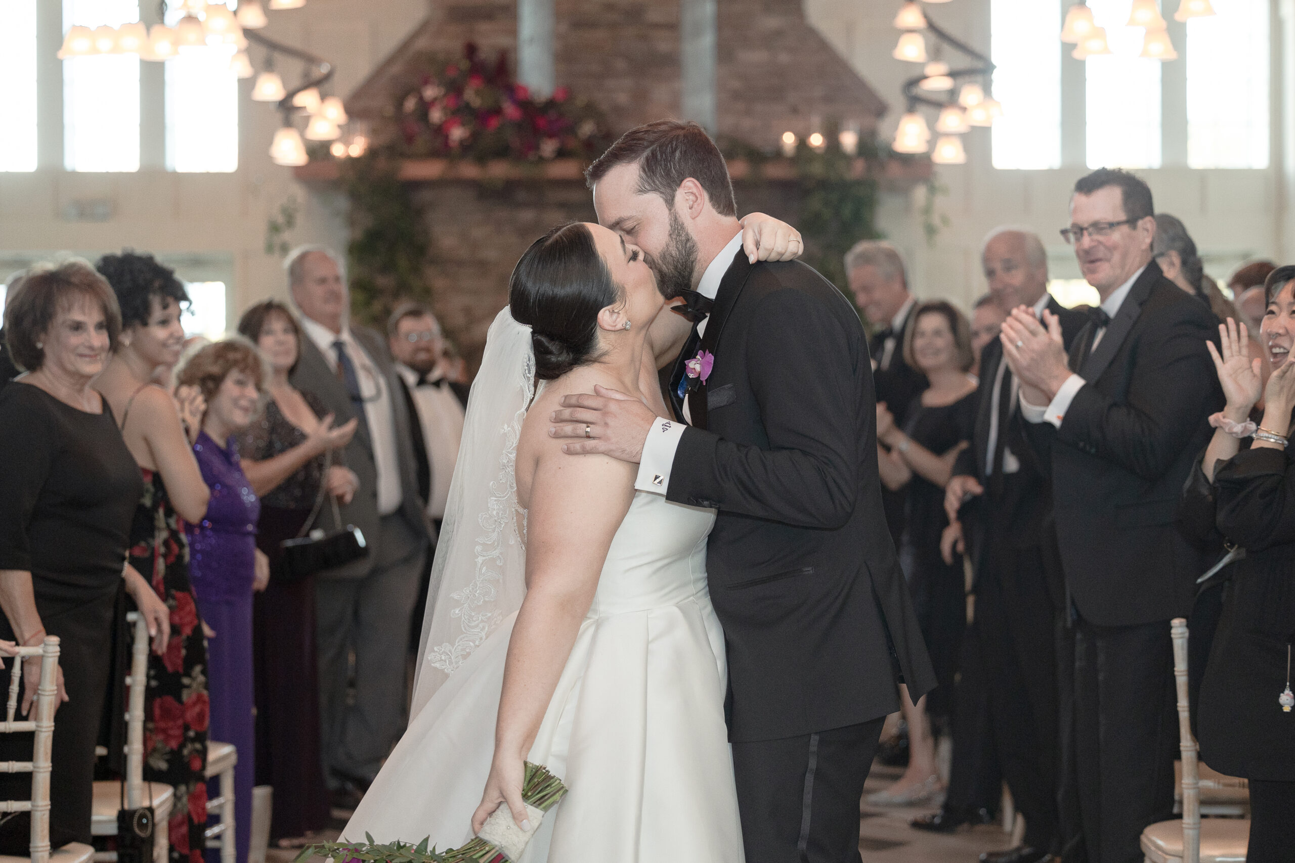 Bride and groom kiss at the aisle