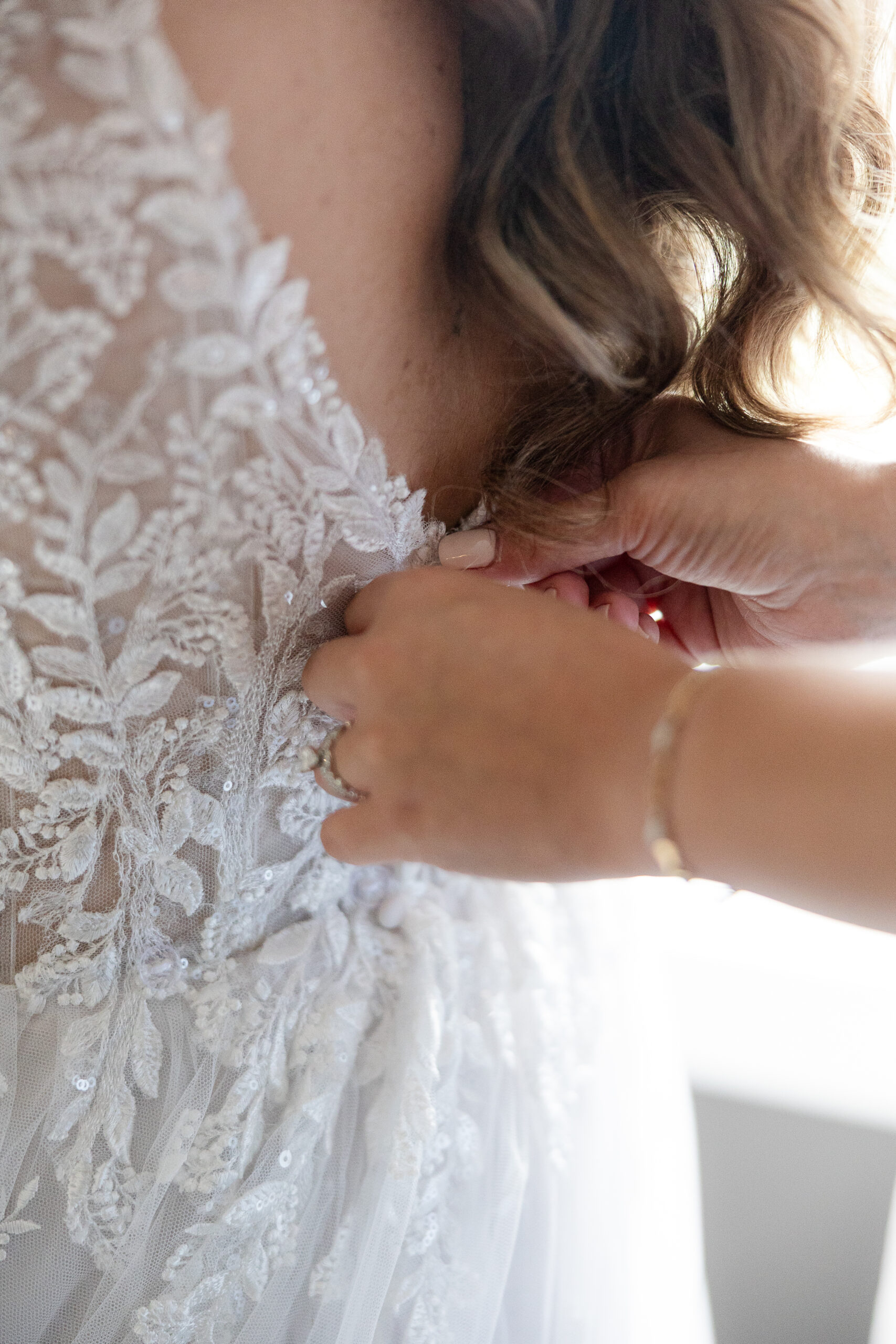 Bride and bridesmaid putting on wedding gown at Bridgewater Marriott Hotel