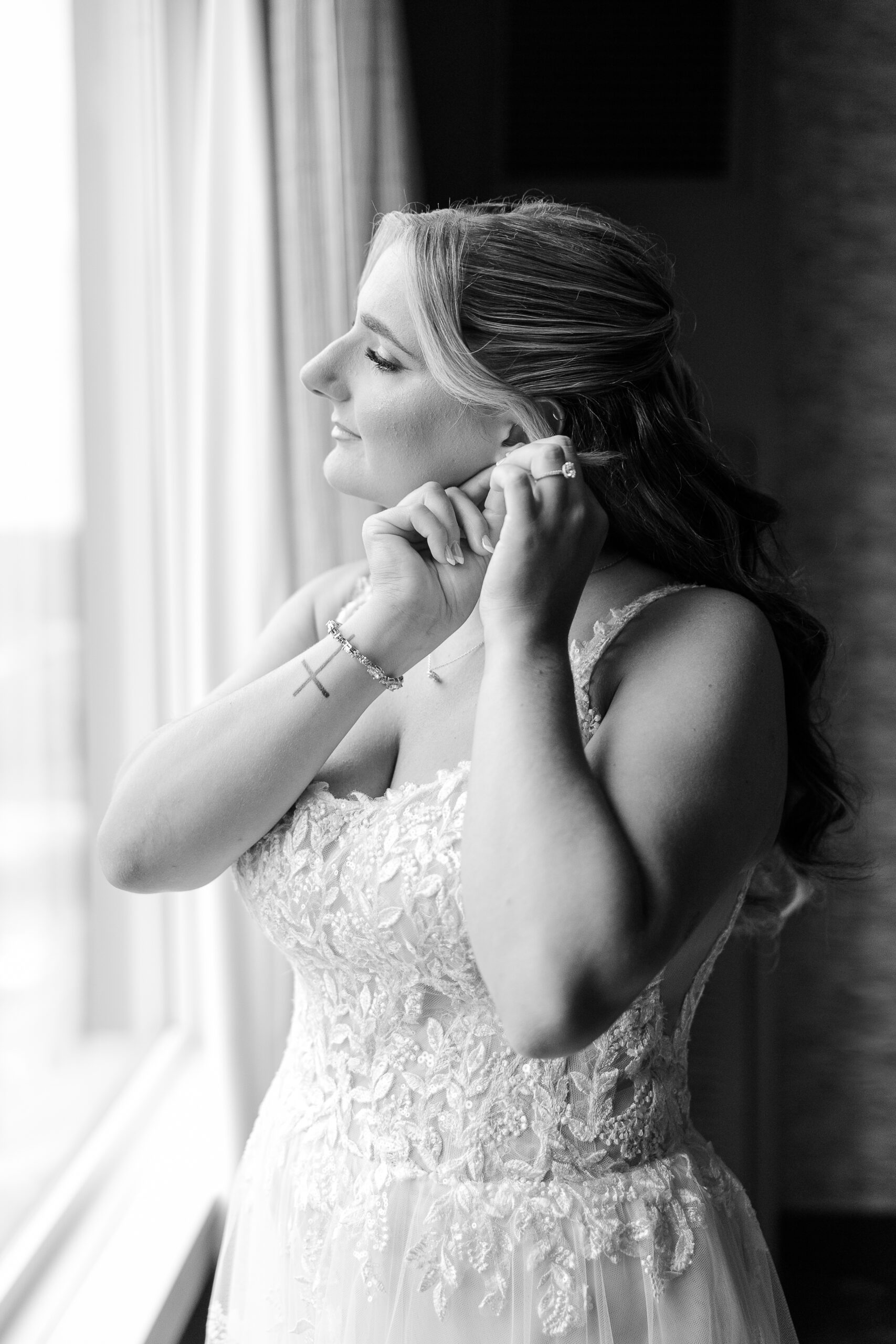 NJ bride putting on earring in Bridgewater Marriott