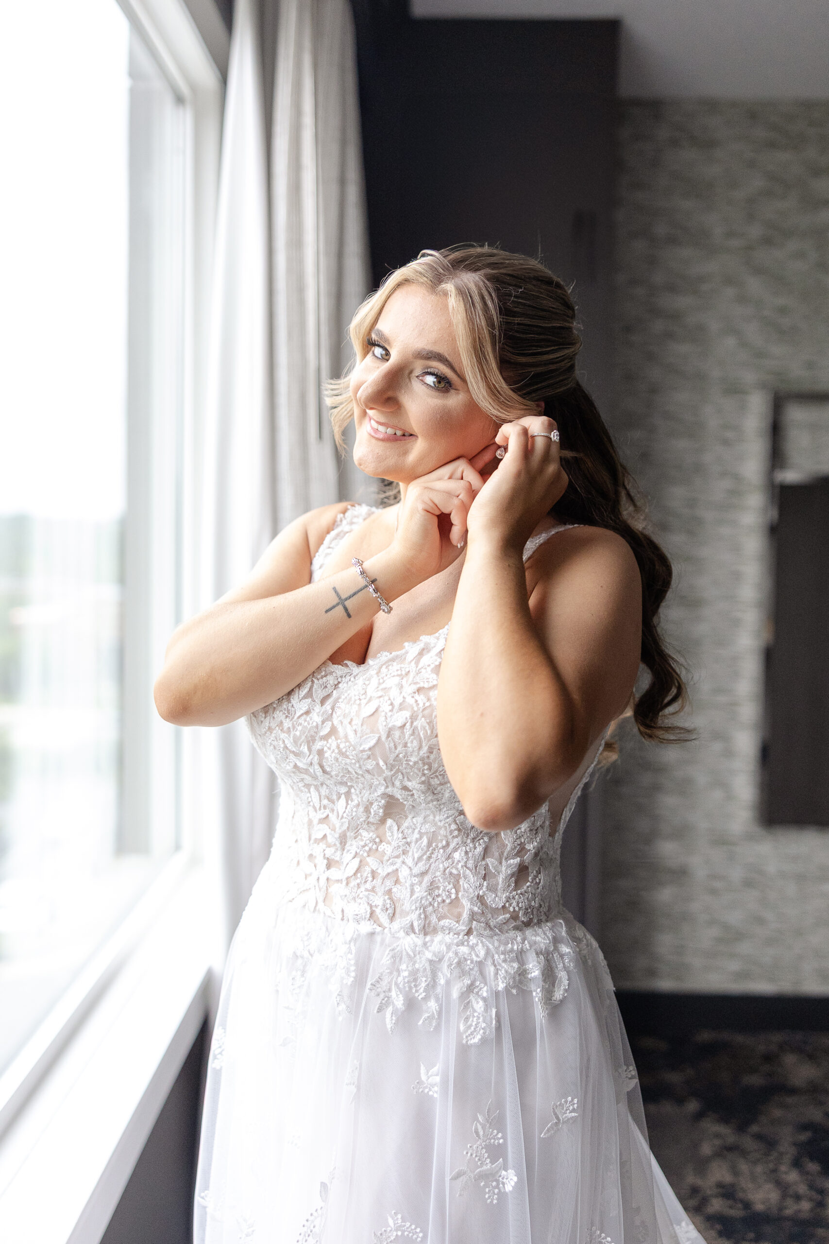 NJ bride putting on earring in Bridgewater Marriott