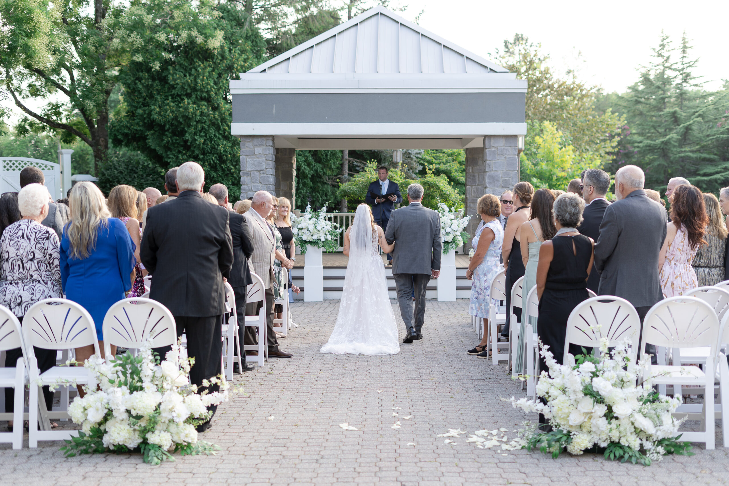 Bride walking down wedding ceremony aisle at Bridgewater Manor