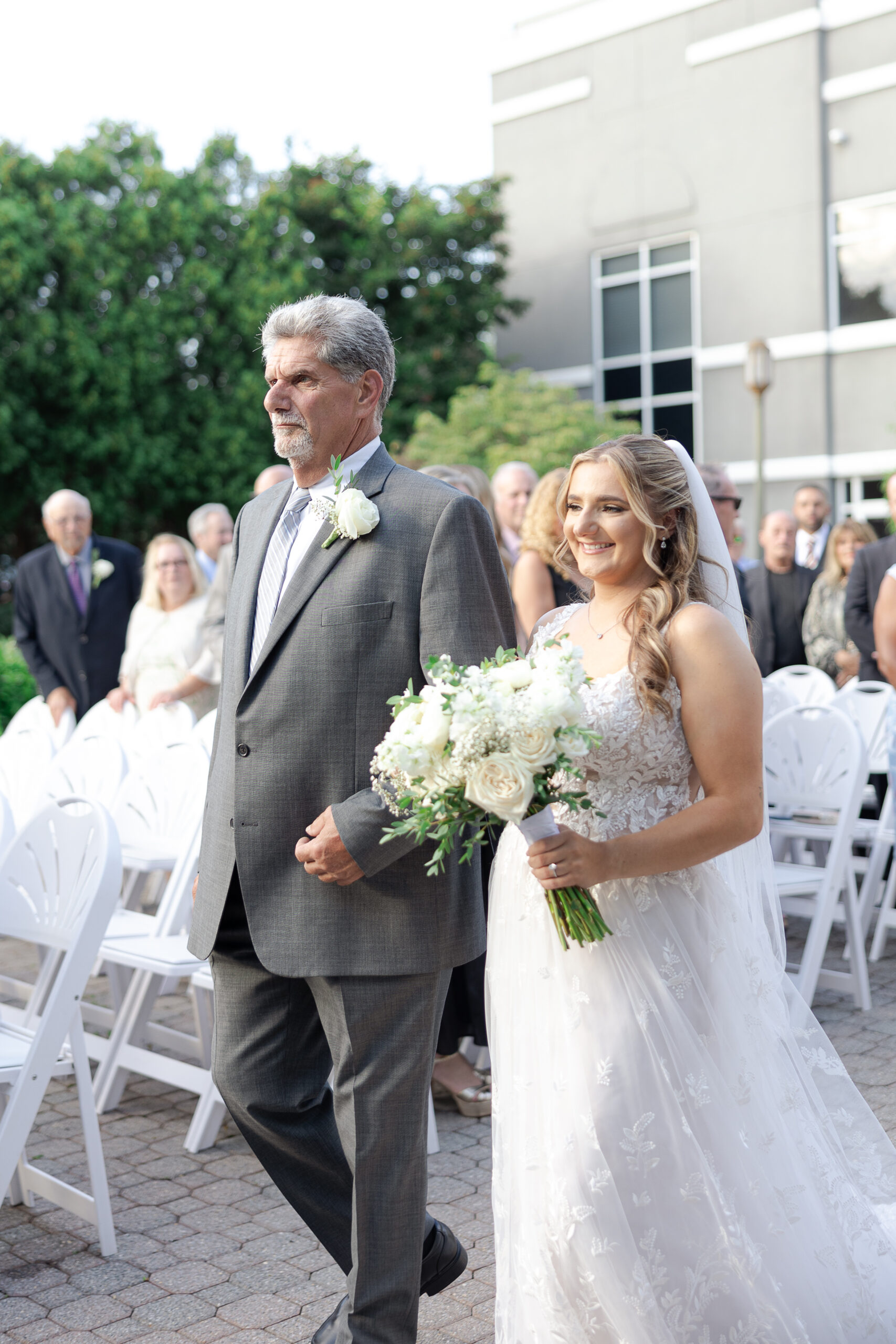 Bride walking down wedding ceremony aisle at Bridgewater Manor