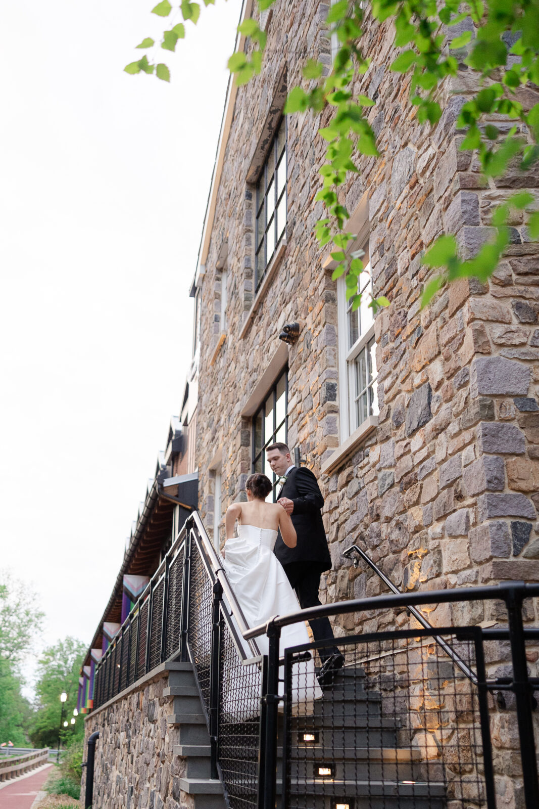 Bride and groom along River House at Odette's exterior balcony