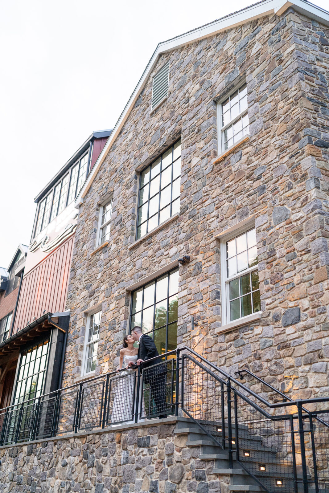 Bride and groom along River House at Odette's exterior balcony