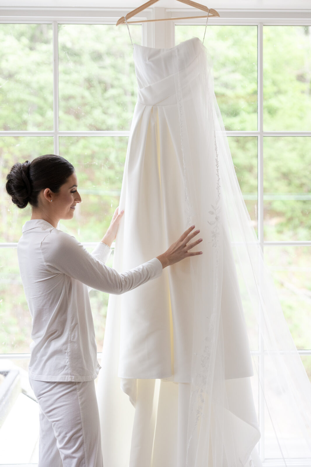 River House bride looking at wedding dress on the hanger