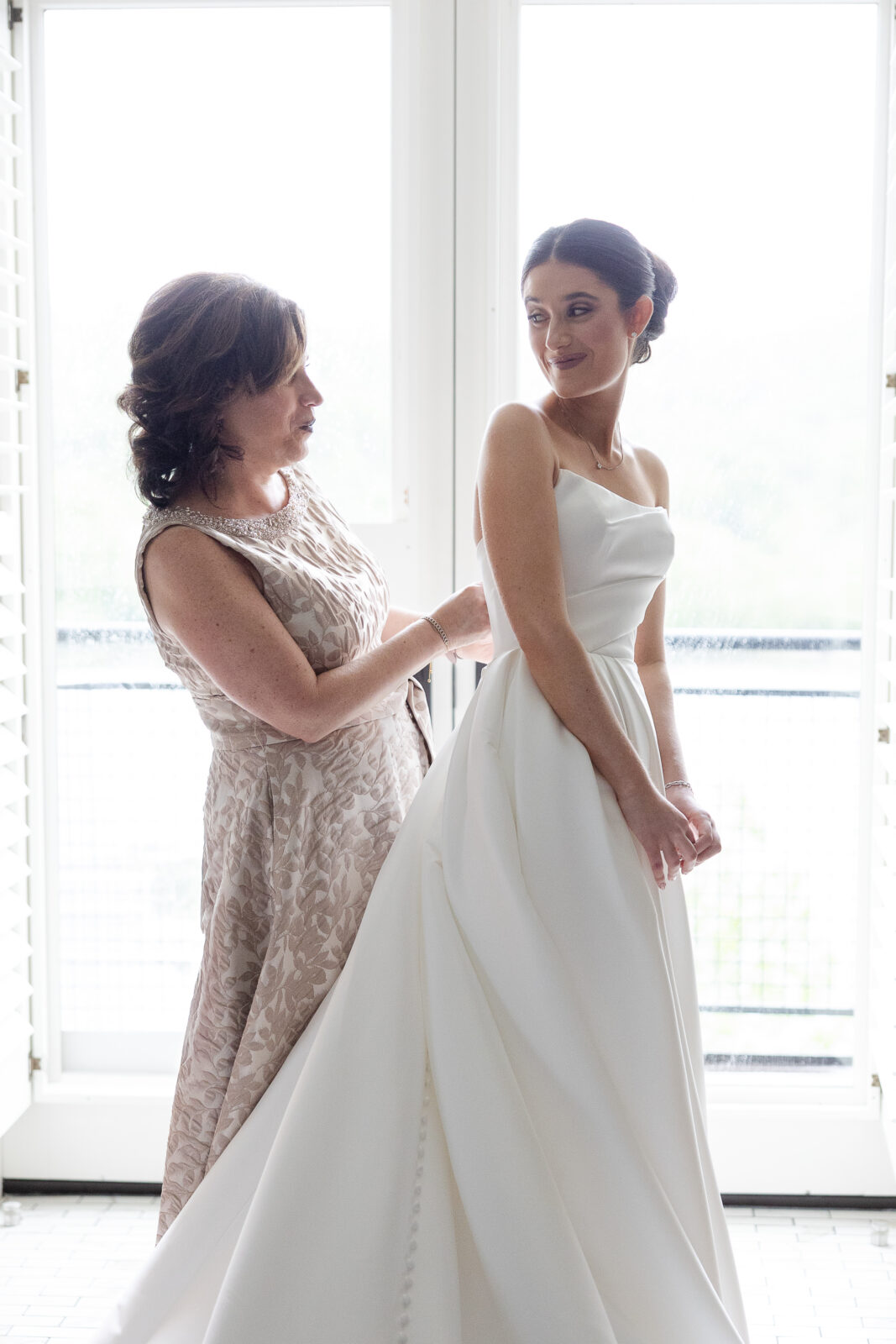 Bride getting dressed with mom