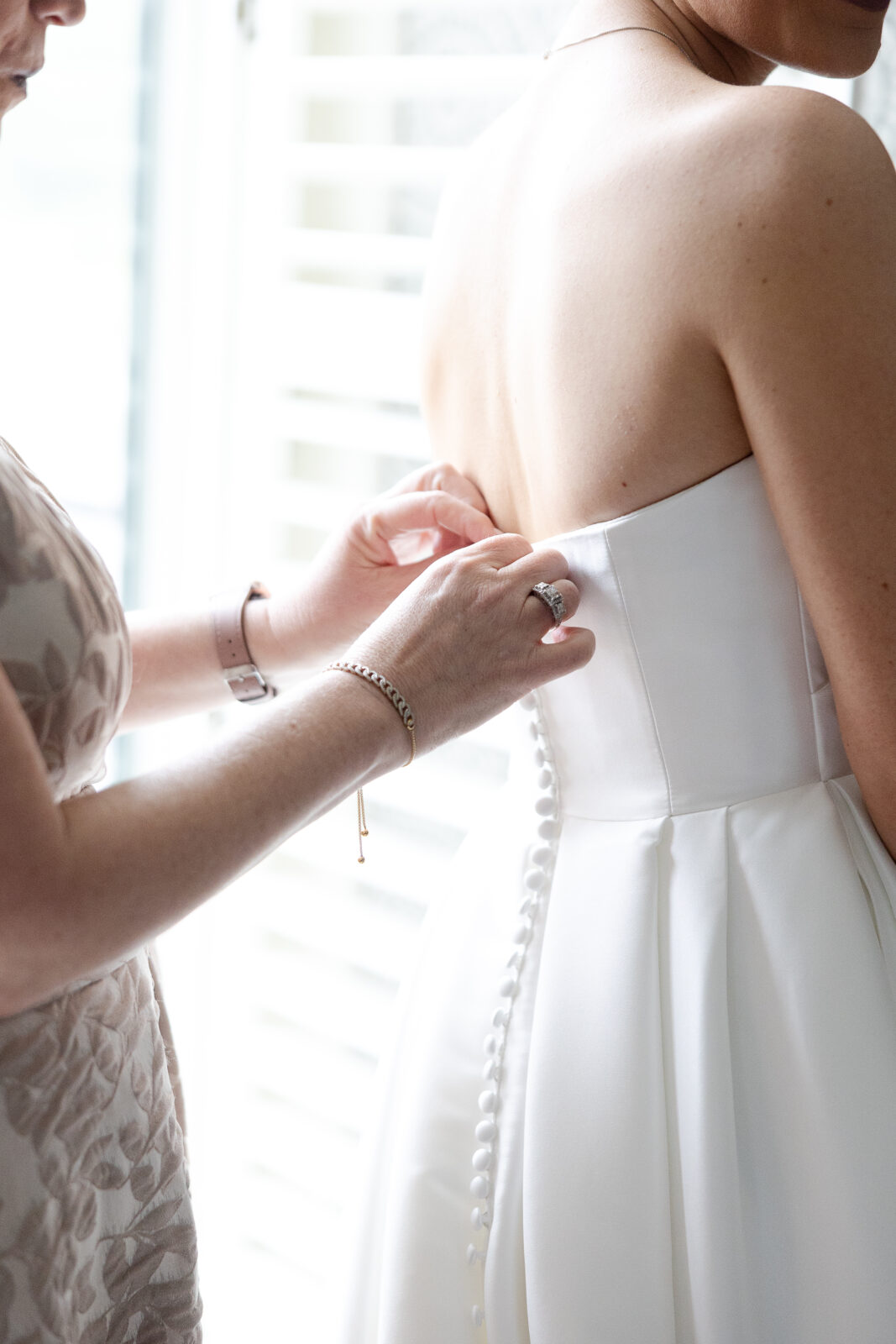 Bride putting wedding dress on