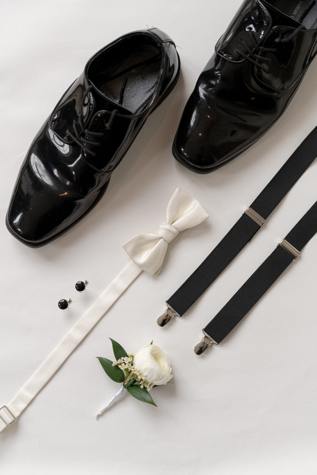 Groom flatlay details with shoes, tie, suspenders