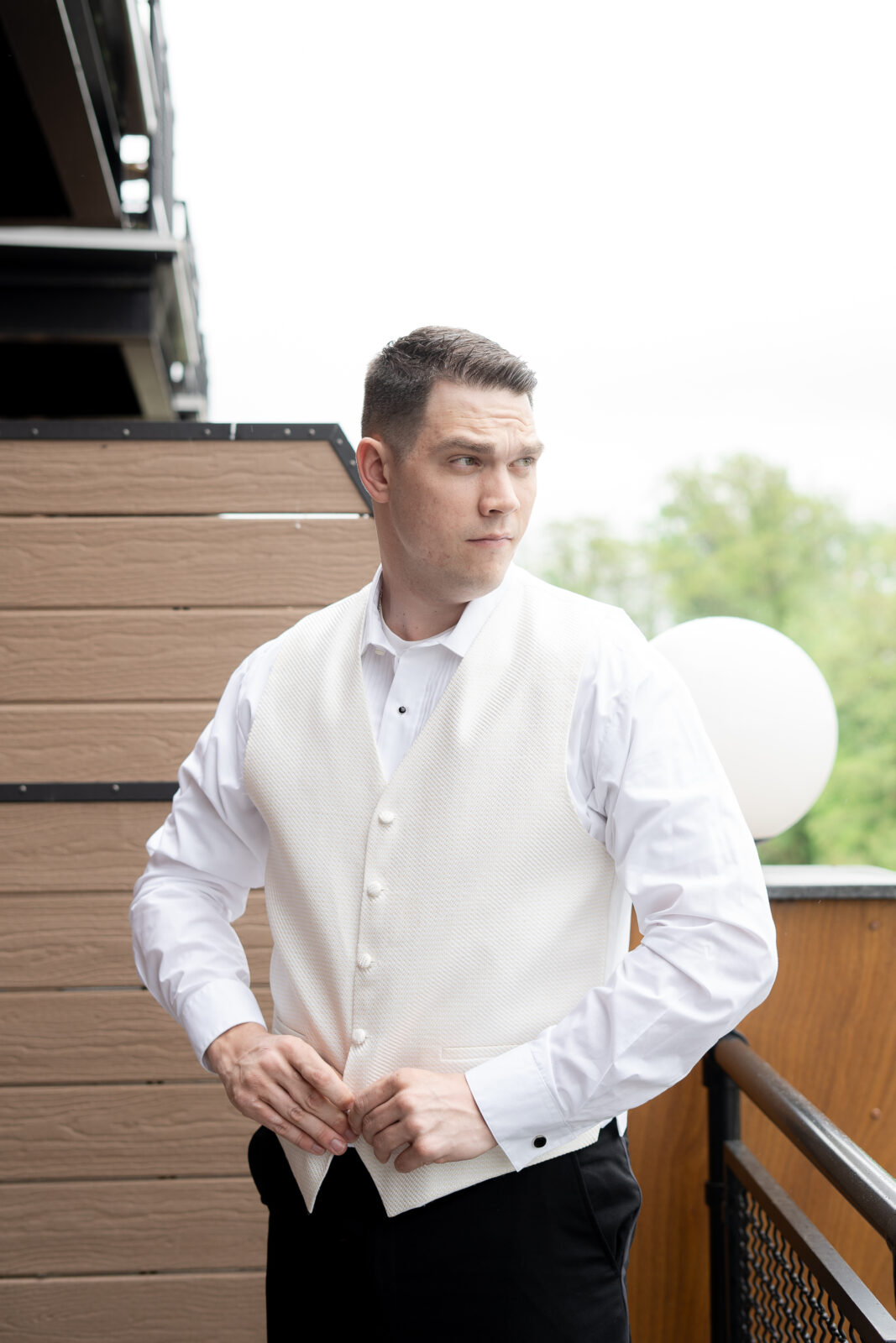 Groom getting dress at groomsmen suite