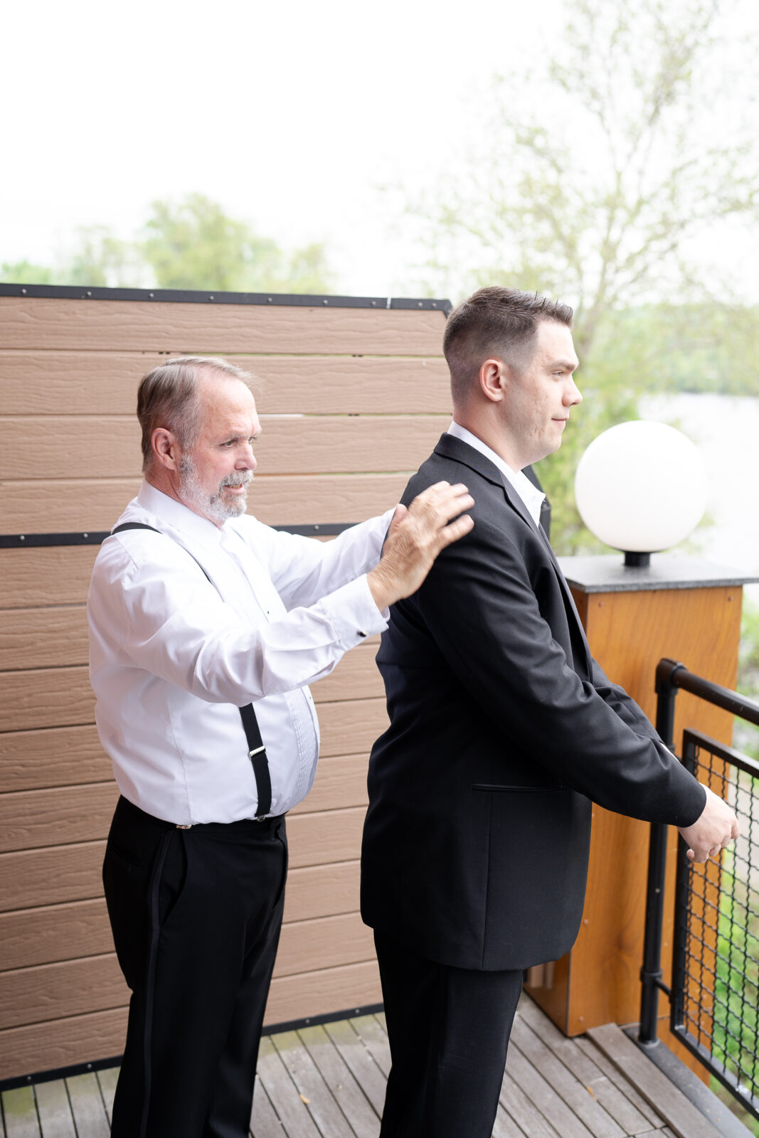 Groom getting dress at groomsmen suite