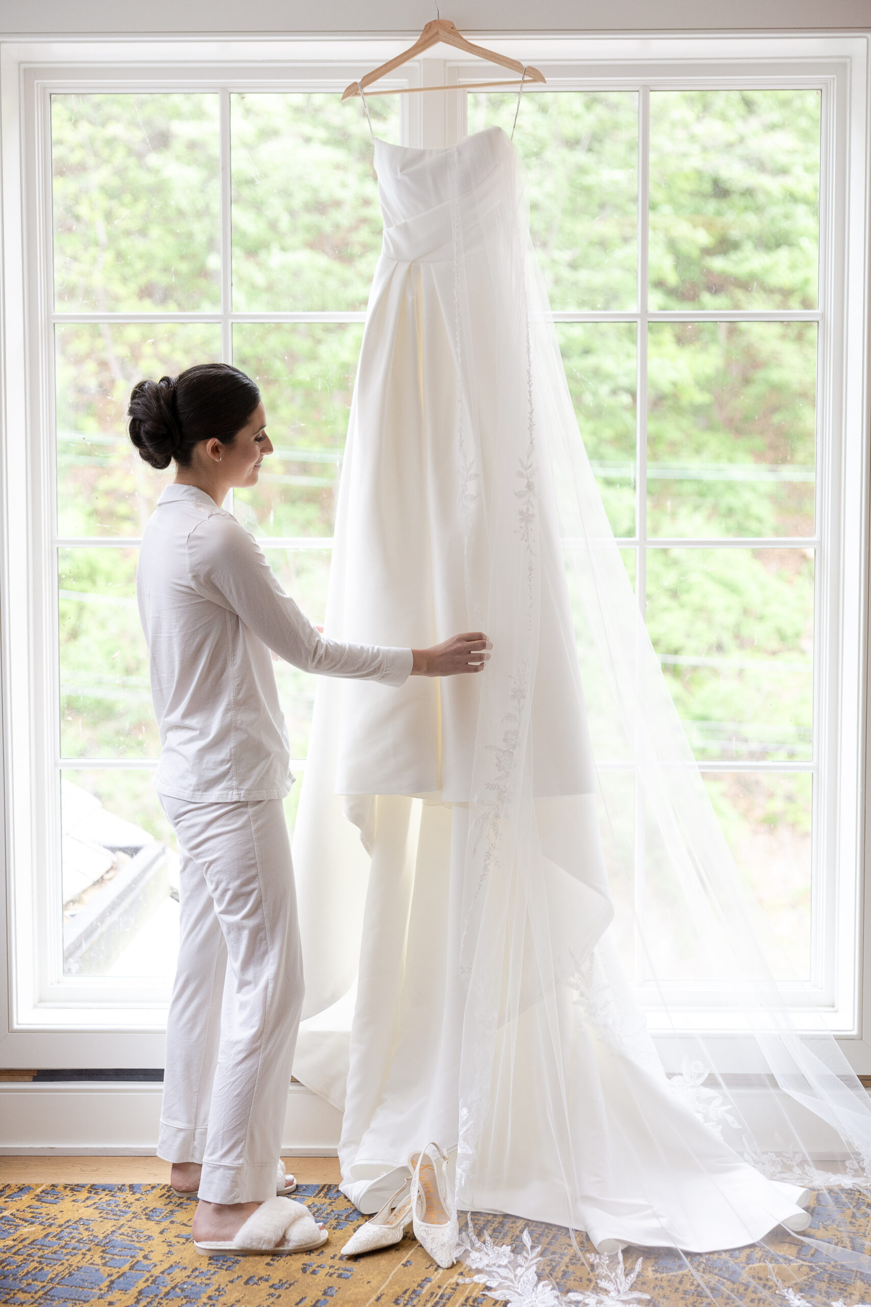 River House bride looking at wedding dress on the hanger