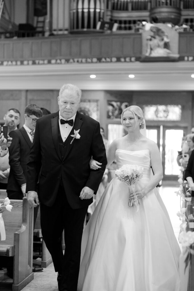 Bride walking down the church aisle during Irish wedding ceremony